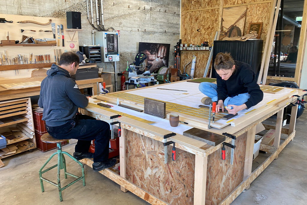 Victoire Camus et Pierre-Henri Beyssac, marqueteurs, dans l'atelier de marqueterie Atelier Beyssac, pendant le montage de leur création "Memento", marqueterie de papier suspendue, dorée à la feuille d'or