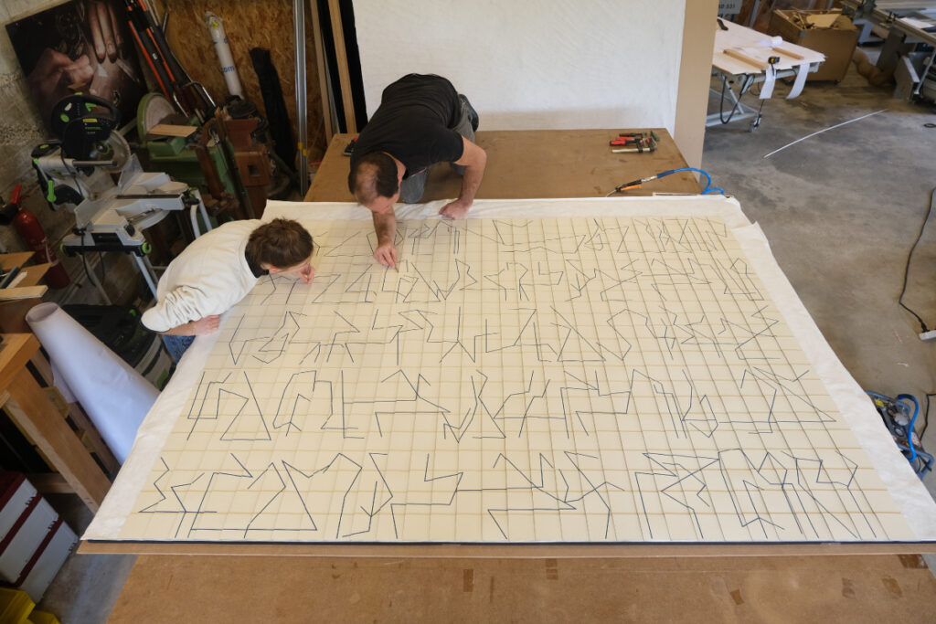 Victoire Camus et Pierre-Henri Beyssac, marqueteurs, dans l'atelier de marqueterie Atelier Beyssac, finalisant leur création "Memento", marqueterie de papier suspendue, dorée à la feuille d'or